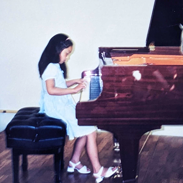Sara learning the piano as a child